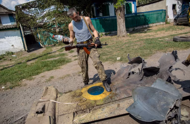 Phiến quân ly khai miền đông Ukraine đứng trên cánh của chiếc máy bay bị bắn rơi.