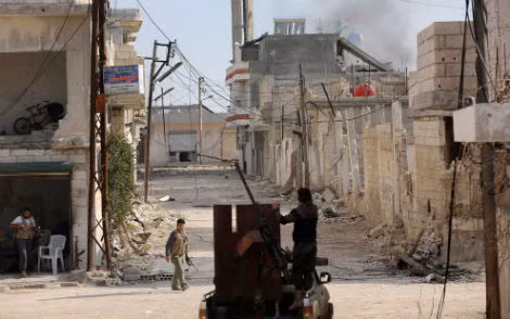 Phe nổi dậy Syria bên khẩu súng máy phòng không được lắp trên một chiếc xe tải ở thị xã Morek tỉnh Hama, ngày 21/3/2014.