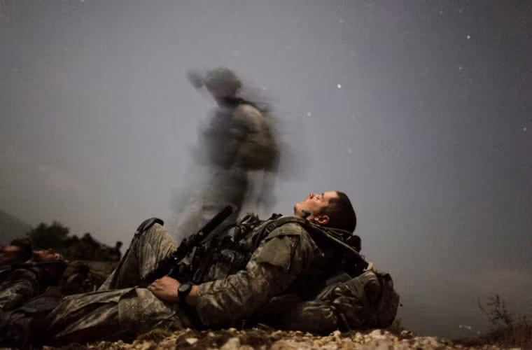 Một người lính NATO tranh thủ nghỉ ngơi trong giờ hành quân.