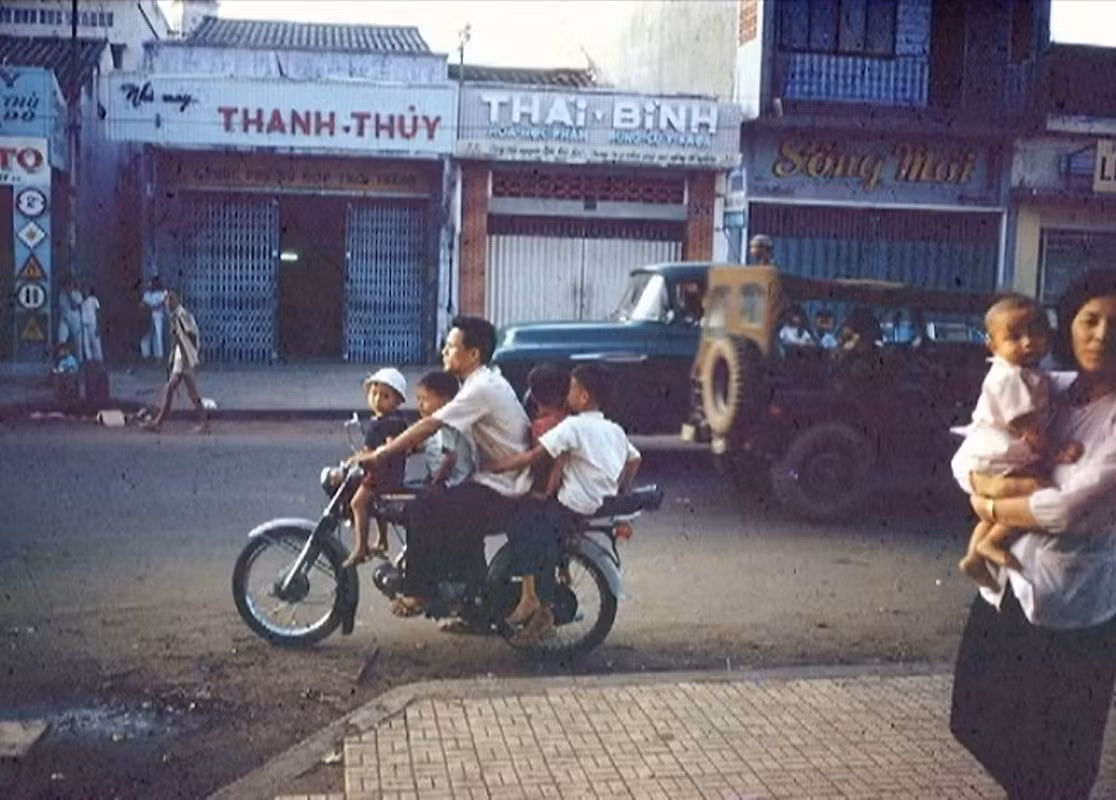 Người đàn ông chở bốn đứa trẻ bằng xe Honda 67 trên đường Phạm Ngũ Lão.