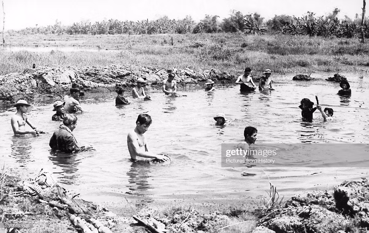 Người dân Củ Chi sử dụng hố bom do máy bay B-52 tạo ra để giặt giũ, 1968.