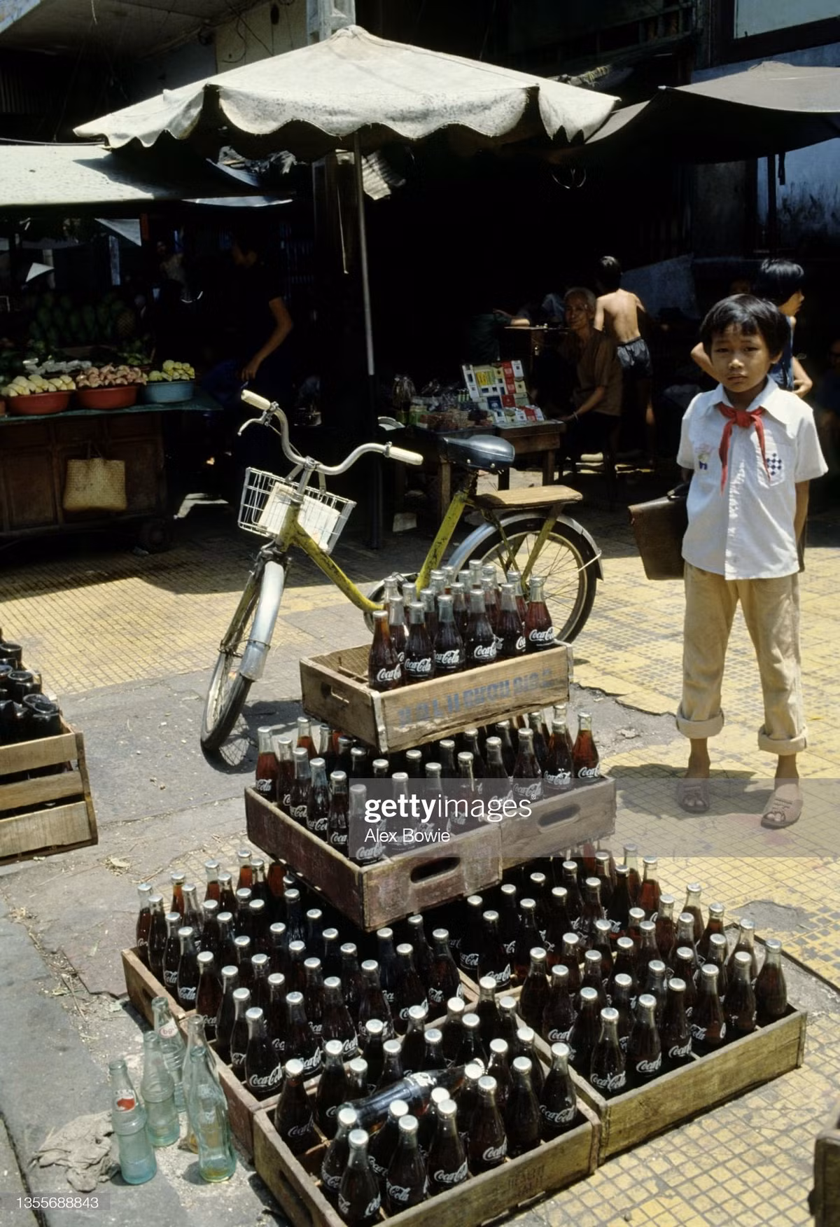 Cậu học sinh nhỏ tuổi đứng cạnh chồng Coca Cola.