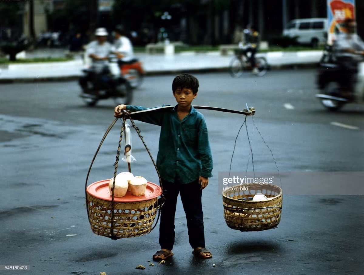 Cậu bé bán nước dừa dạo trên đường phố TP. HCM.