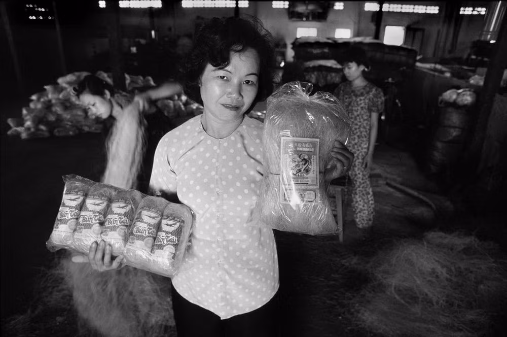 Bà Lê Thị Thu Nguyệt, giám đốc của Cửa hàng thực phẩm quân Tân Bình (TP HCM) đang trưng ra các sản phẩm bún tàu (miến), một trong những mặt hàng bán chạy nhất do cơ sở của bà sản xuất, trong đó có loại miến đóng gói với nhãn xanh phục vụ xuất khẩu, năm 1988.