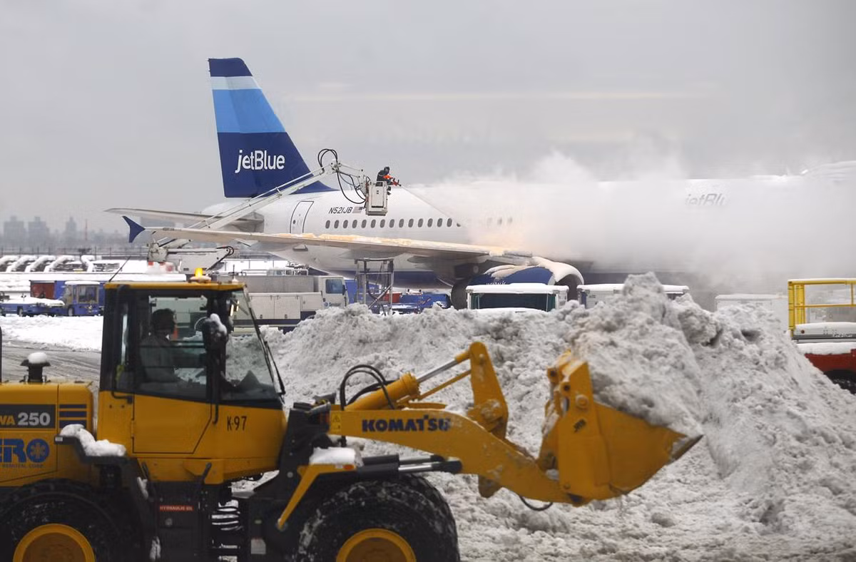 Máy xúc tuyết dọn tuyết tại đường băng của sân bay LaGuardia ở quận Queens của New York. Bão mùa đông khiến giao thông đường hàng không bị ảnh hưởng nặng nề. Ước tính 200.000 chuyến bay bị trì hoãn hoặc hủy bỏ. Sân bay LaGuardia cũng phải trì hoãn nhiều chuyến bay.