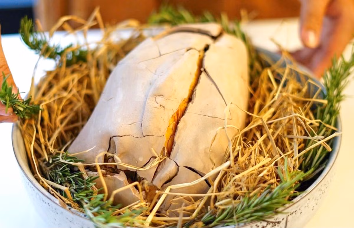 Gà nướng đất sét (hay còn có tên "gà ăn mày") là món ăn có nguồn gốc từ Trung Quốc. Đặc sản này cũng quen thuộc với người miền Tây. Gà được sơ chế kỹ, tẩm ướp gia vị. Nguyên liệu quan trọng tạo mùi thơm là lá chanh và sả băm nhét vào bụng gà. Khi đã ngấm vị, người làm tiếp tục lấy lá sen, lá chuối bọc quanh rồi đắp đất sét lên cho thật kín, cuối cùng đem nướng từ từ trên lửa nhỏ. Ảnh: Sapconceptstore.