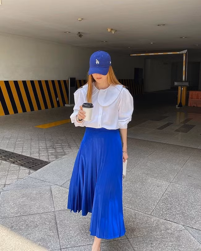 Áo blouse trắng + chân váy xanh biển đủ nổi bật và trẻ trung, nhưng vẫn đem đến sự thanh lịch, tạo sự chỉn chu, gọn gàng.