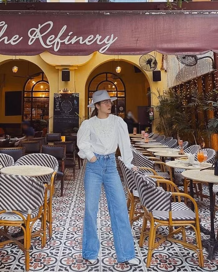 Yến Nhi chọn thiết kế quần jeans ống rộng, cạp cao, kết hợp cùng áo blouse trắng. Cô nàng còn khéo chọn giày và mũ fedora tiệp màu trắng tạo nên một tổng thể tinh tế.