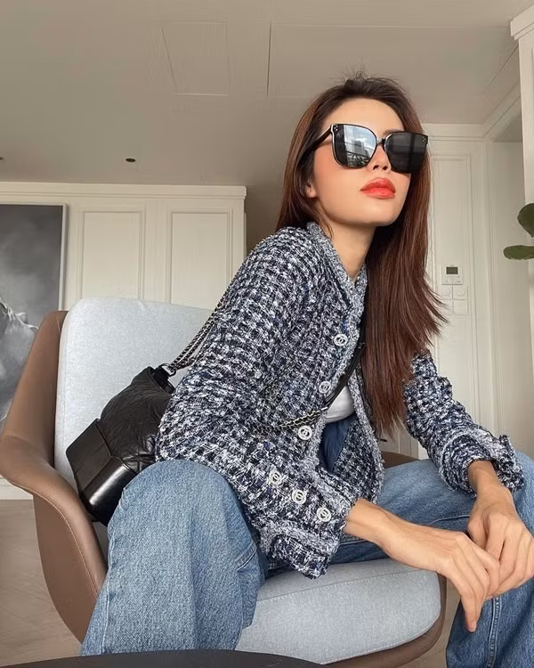 Siêu mẫu Minh Tú lại chọn phòng khách với đạo cụ là chiếc ghế armchair cho bức hình thời trang lần này. Minh Tú diện cây đồ hiệu kết hợp áo blazer vải twist và túi xách đen cứng cáp cùng thương hiệu. Quần jean ống rộng và kính mắt mèo tone đen mang đến cái nhìn hiện đại và cá tính.