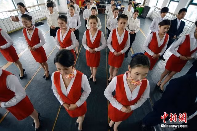 Tổng cộng 54 nữ sinh ngành tiếp viên tại Đại học Hàng không và Vũ trụ Nam Kinh đã được đào tạo về nghi thức, trong đó có học cách mỉm cười với chiếc đũa ngậm trong miệng hoặc đi bộ thăng bằng với cách cân bằng những cuốn sách trên đầu.