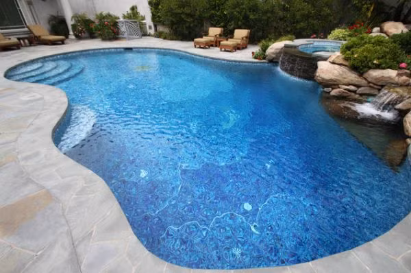 Bạn cũng có thể tạo điểm nhấn cho bể bơi bằng cách xây thêm thác nước hay khu tắm spa bên cạnh.