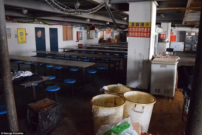 Phòng ăn chật chội, bàn ghế được thiết kế sao cho “nhét” được nhiều công nhân nhất có thể. Trên trần vẫn còn đồ trang trí cho tiệc giáng sinh đón năm mới.