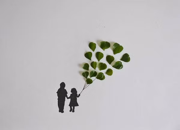 Cha dắt cô con gái cầm chùm bóng bay trên con đường về.