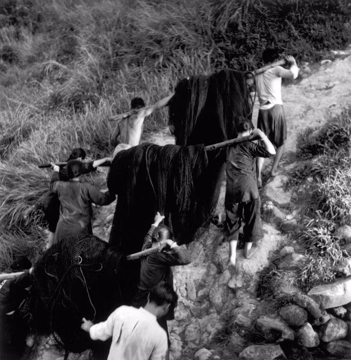 Các ngư dân của làng chài Kau Sai vác lưới lên núi để phơi. Ảnh: Werner Bischof / Magnum Photos.