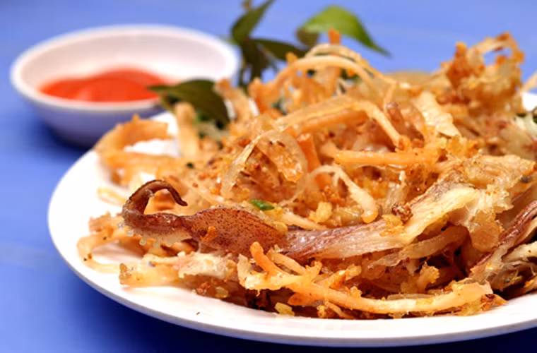 Khô mực chiên bơ. Không mang lại cảm giác dai khó cưỡng như khô mực nướng nhưng khô mực chiên bơ lại “đốn tim” người ăn bằng vị giòn rụm, cay cay vị tương ớt. Khô mực chiên bơ sẽ khiến anh ấy ăn mãi không chán, bất chấp cảm giác nóng hầm hập ngày hè.