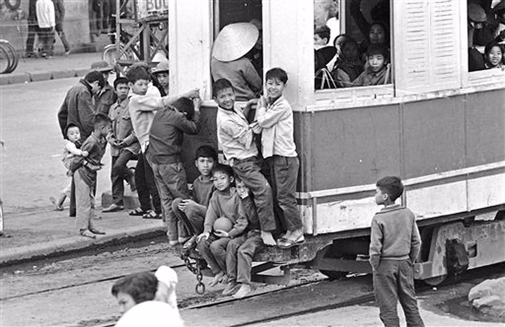 Một nhóm thiếu niên "bám càng" tàu điện, 2/4/1973. Để đu lên phía sau toa tàu đang chạy một cách an toàn, cần có kỹ thuật "nhảy tàu" điêu luyện.