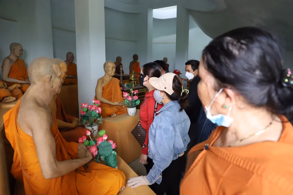 Người dân xem các bức tượng đặt bên trong tượng Phật Di Lặc.