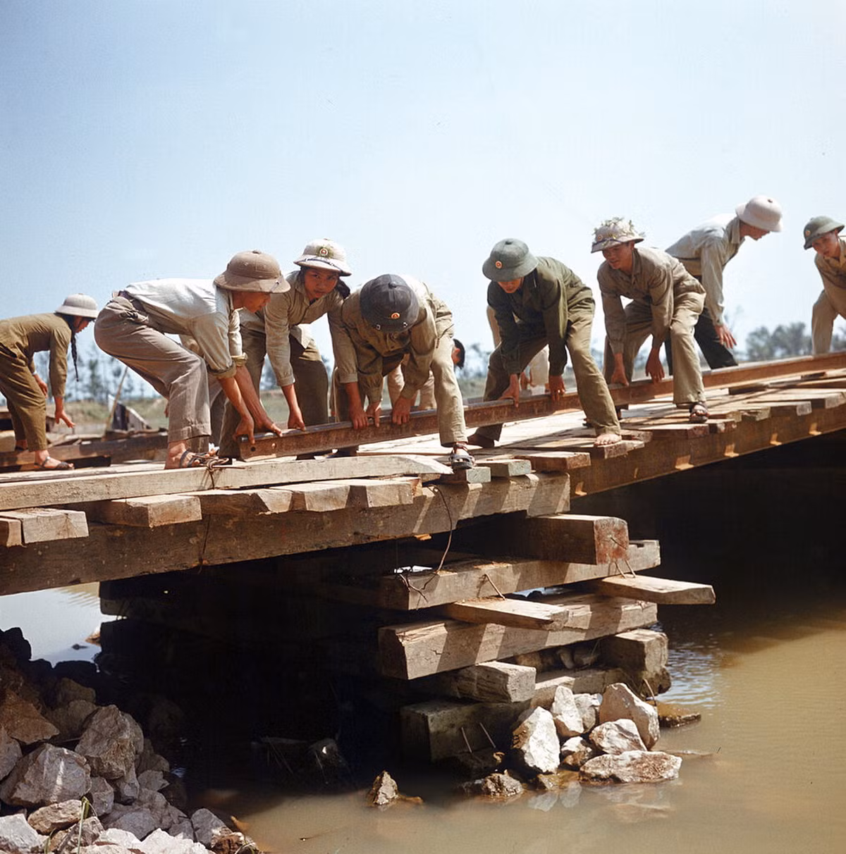 Lực lượng thanh niên xung phóng xây dựng một cây cầu tạm bắc qua sông gần Đồng Hới, Quảng Bình.