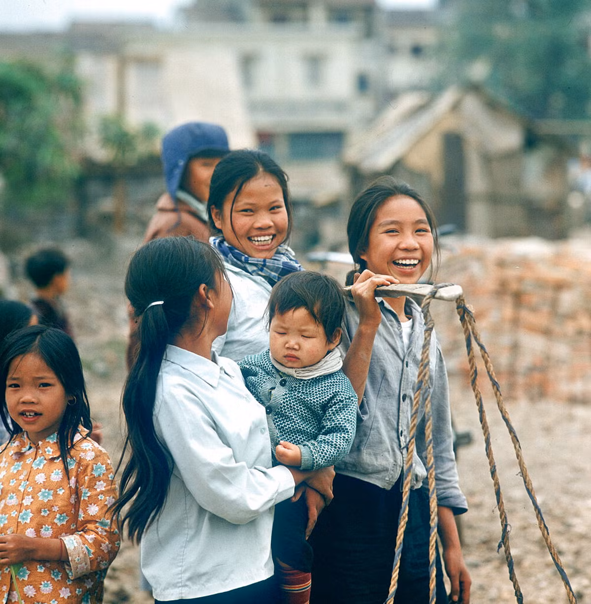 Nụ cười hồn nhiên của các bé gái Hà Nội giữa khu phố đang được tái thiết từ đống đổ nát của chiến tranh.