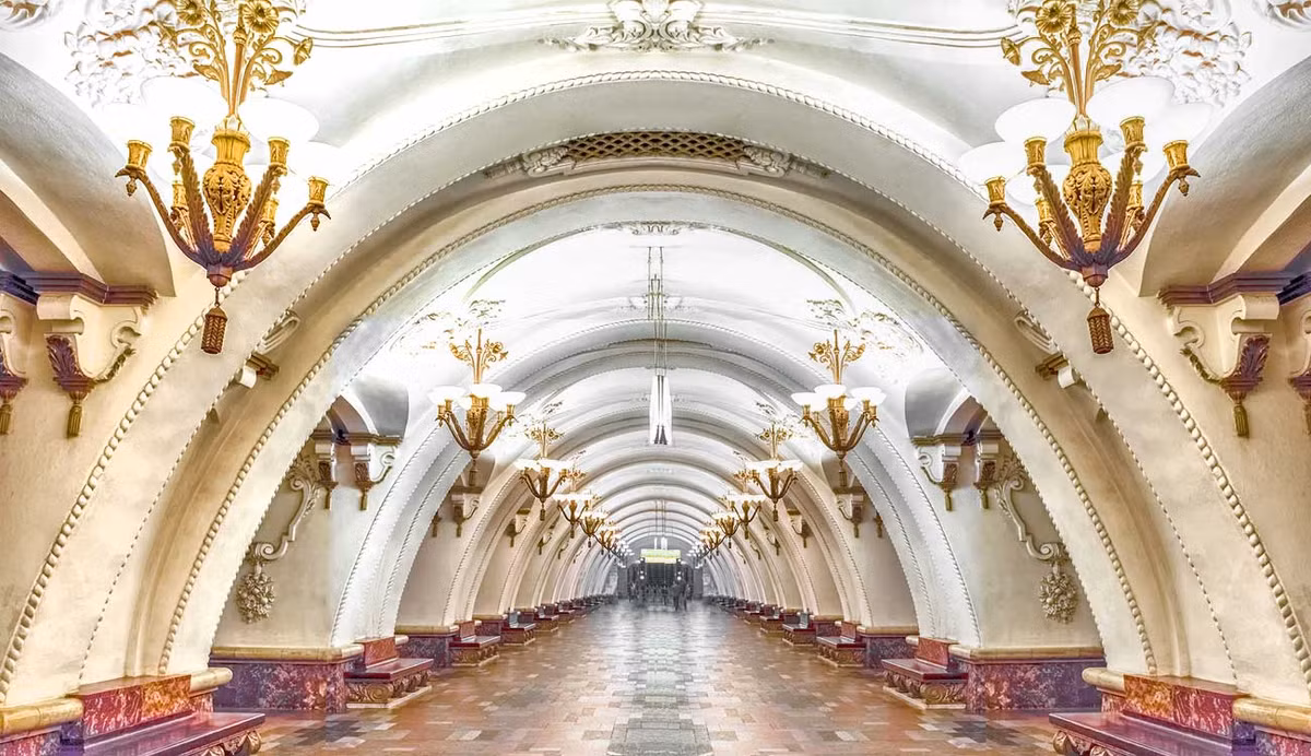  Ga Arbatskaya (Арба́тская, Tuyến số 3). Vòm trần cao được trang trí công phu với các đèn chùm lộng lẫy tạo nên sự tương phản tuyệt vời với sàn đá cẩm thạch màu đỏ của nhà ga tàu điện ngầm này.