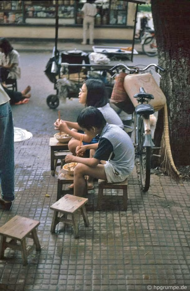Bữa sáng trên vỉa hè Sài Gòn của hai em bé.