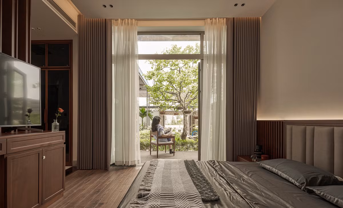 Phòng ngủ chính có cánh cửa kính lớn thông ra vườn, hồ cá, tạo cảm giác như một khu nghỉ dưỡng - nơi gia chủ có thể đọc sách, thưởng trà mỗi sáng bình minh.