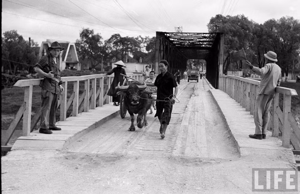 Người dân qua lại trên cầu Kỳ Lừa, thị xã Lạng Sơn năm 1950. Ảnh: Carl Midans / Life.