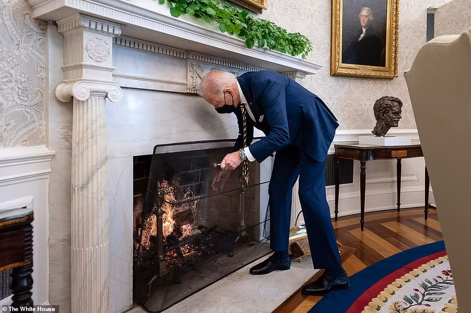 Tổng thống Joe Biden thêm củi vào lò sưởi trong Phòng Bầu dục ngày 22/1.