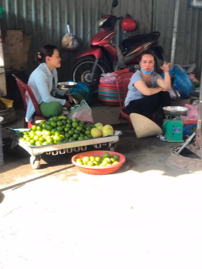 Tiểu thương không đeo khẩu trang hoặc đeo không đúng cách tranh thủ "tám chuyện" khi vắng khách.