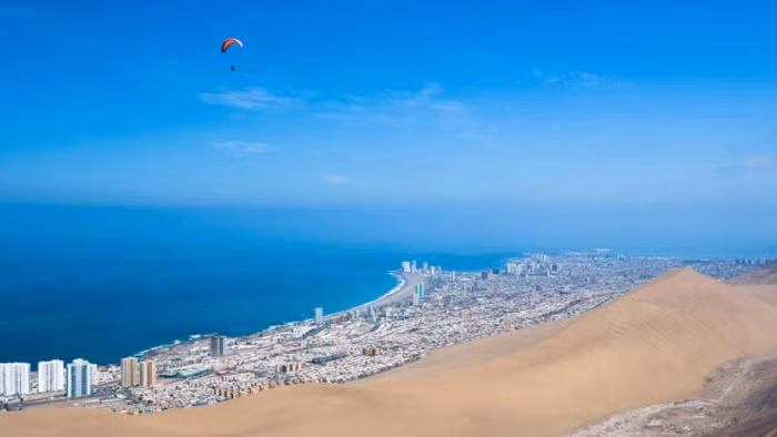 Iquique, Chile. Iquique là thành phố ven biển nằm ở phía Bắc Chile và phía Tây sa mạc Atacama. Nó chỉ nhận được lượng mưa hàng năm chỉ 5mm, thường mưa vào tháng Một hoặc tháng Hai. Mặc dù là một trong những nơi khô hạn nhất trên thế giới nhưng Iquique thu hút rất nhiều du khách đến nghỉ dưỡng. Thành phố này có một số bãi biển giúp xua bớt sự khô hạn cũng như một loạt các khu nghỉ mát tuyệt vời. Du khách cũng bị hấp dẫn bởi trò chơi lướt sóng, mua sắm miễn thuế và sòng bạc bên bờ biển.