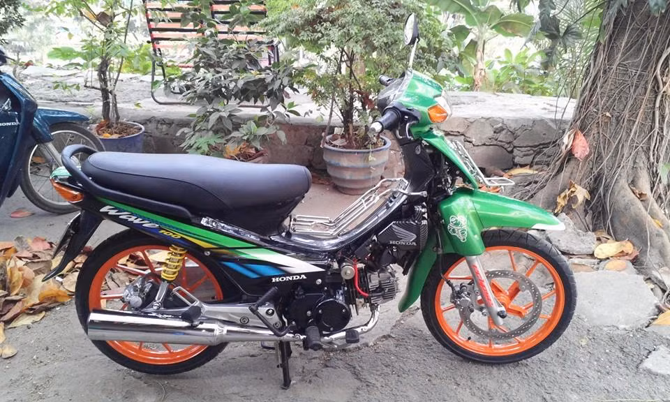 Honda Wave là một trong những dòng xe thu hút khá nhiều dân chơi xe độ ở Việt Nam. Chiếc Wave này nổi bật với dàn áo màu xanh và dàn chân màu cam sống động.