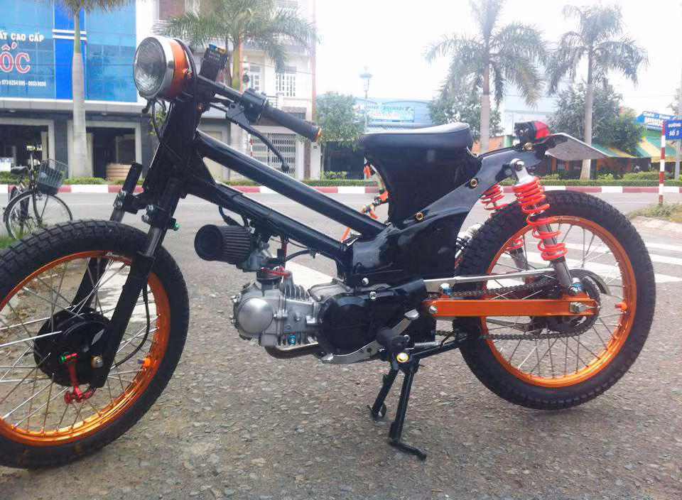 Từ một chiếc Honda Cup với dáng vẻ đặc trưng kinh qua năm tháng, dân chơi ở Tiền Giang đã hóa phép chiếc xe trở nên đẹp và mạnh mẽ hơn. Với phong cách khá sốc cùng tông màu đen cam nổi bật, chiếc xe thu hút ánh nhìn của người xem.