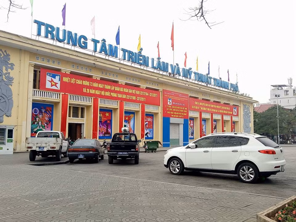 Ghi nhận của VietNamNet, sau lệnh cấm, hầu hết xế hộp không đỗ tại dải trung tâm nhưng lại chui vào công viên, leo lên vỉa hè. Khu vực công viên tượng đài nữ tướng Lê Chân nhiều ngày nay bỗng trở thành bãi ô tô mới. Ảnh: Mặt tiền trung tâm triển lãm bị xe biển xanh bủa vây