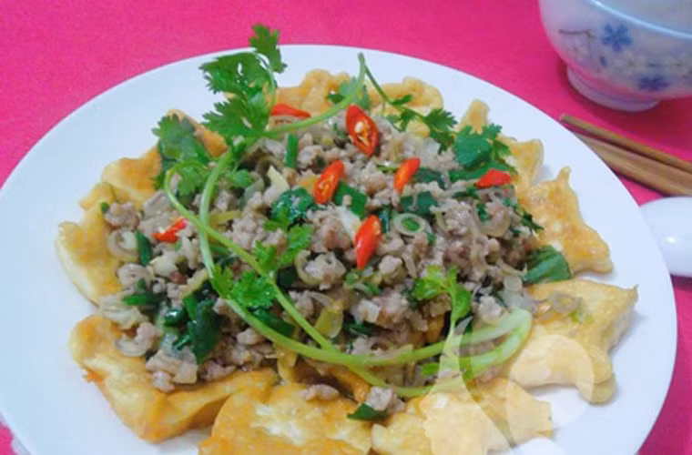  Đậu phụ sốt thịt băm. Đậu phụ sốt thịt băm khá đẹp mắt khi kết hợp hoàn hảo với màu đỏ của ớt, xanh rì của hành, lá mùi và vàng ươm của đậu phụ rán. Đặc biệt, món ăn không hề mang lại cảm giác ngấy mỡ, đưa cơm.