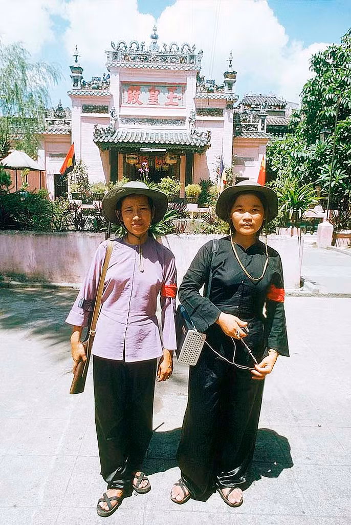 Hai nữ chiến sĩ đứng trước chùa Ngọc Hoàng năm 1975, sau khi Sài Gòn được giải phóng. Ảnh của phóng viên Herve Gloaguen.