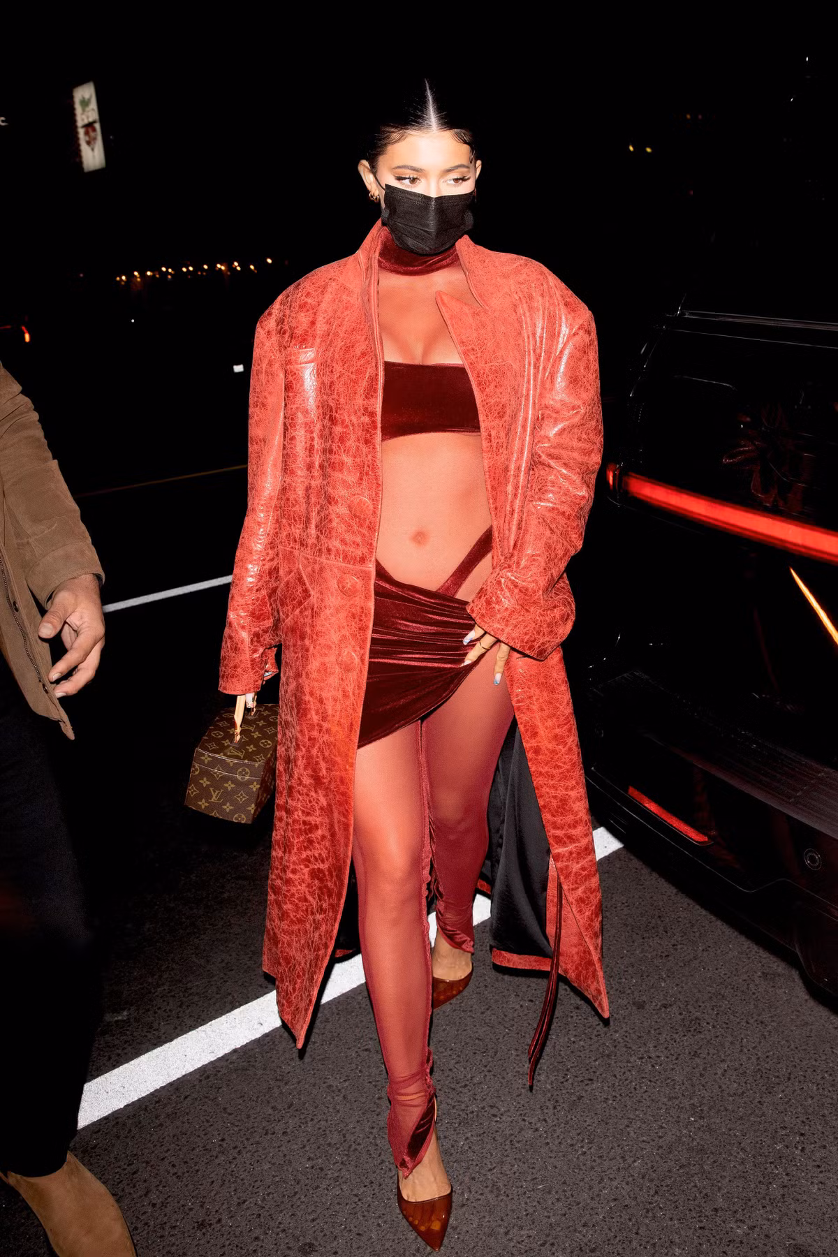 Kylie Jenner cũng ưa chuộng thiết kế tông màu đỏ. Cô kết hợp 2 chất liệu nhung và vải xuyên thấu trên cùng bộ trang phục. Vẫn diện kiểu dáng đồ cắt xẻ táo bạo, nhưng người đẹp tránh được sự phản cảm nhờ cách phối jumpsuit bên trong và khoác ngoài áo da của Louis Vuitton.