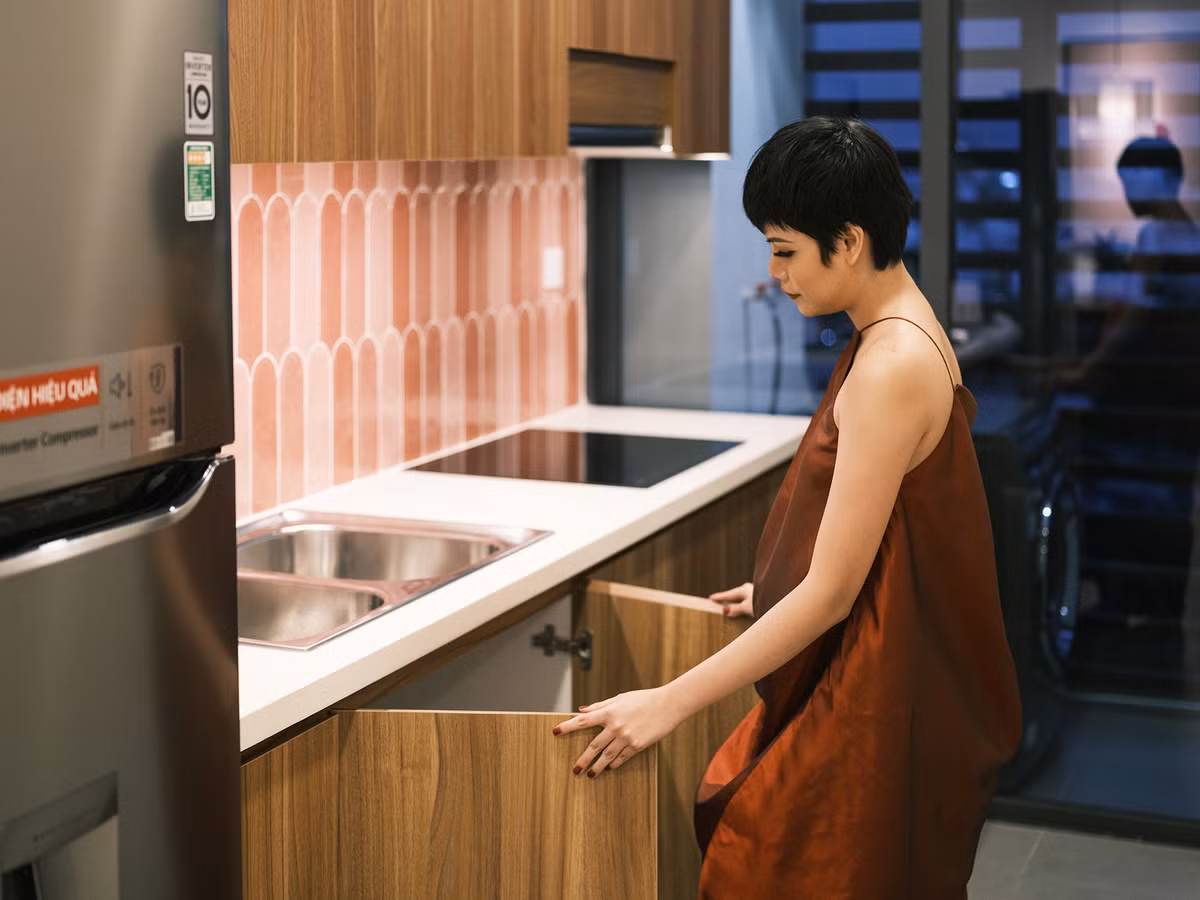 Hệ thống bếp được thiết kế đơn giản với điểm nhấn là mảng tường gạch men màu hồng phấn.