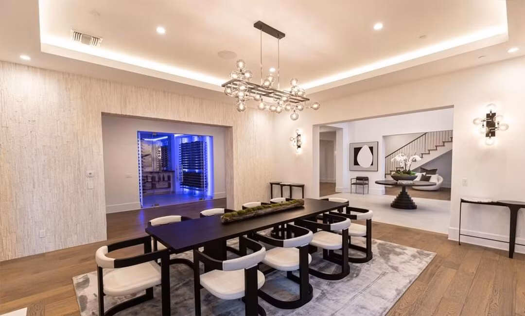 Bàn ăn lớn, đủ chỗ cho 10 người. Nằm sát phòng ăn là một phòng chứa rượu vang hiện đại cùng hệ thống đèn LED tùy chỉnh.