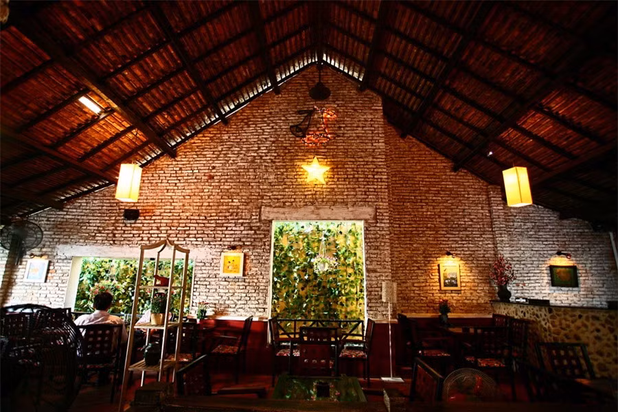 Kiến trúc cũ ấn tượng với những bức tường gạch trần và bộ mái dốc lớn. Không gian xưa cũ gợi nét thâm trầm.