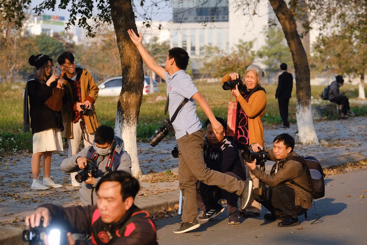 Anh Lê Xuân Bách (giữa, áo xanh) cùng nhóm bạn rủ nhau chụp ảnh mẫu. Anh Bách cho biết mỗi người trong đoàn sẽ chia nhau ném lá, vác thang, hắt sáng để có tấm hình đẹp nhất.