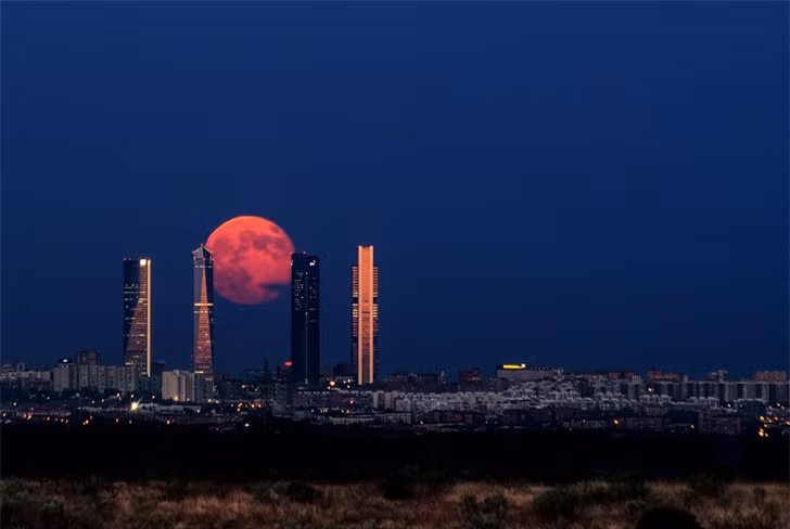 Mặt trăng đang "leo" lên những tòa nhà cao vút tại thành phố Madrid, Tây Ban Nha.