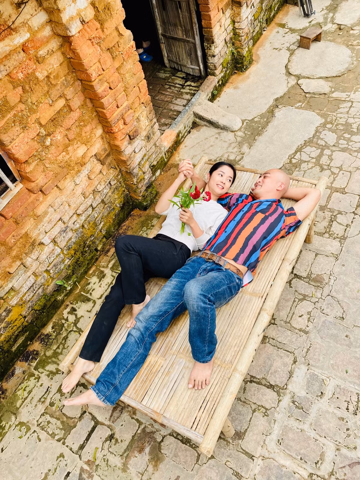 Doãn Quốc Đam cũng vừa chia sẻ loạt ảnh chụp cùng người vợ màn ảnh trên một chiếc chõng che ở bối cảnh phim khiến nhiều khán giả thích thú.