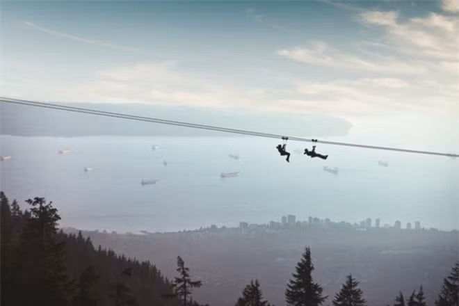 Ngắm Vancouver từ zipline: Một trong những cách khám phá Vancouver mang lại cảm giác mạnh là đi zipline qua cánh rừng già, những mỏm núi, khe núi ở dãy Grouse Mountain. Nơi đi zipline cách trung tâm Vancouver chưa đến 30 phút lái xe, có thể đi bằng xe buýt và các phương tiện giao thông công cộng. Ảnh: Grouse Mountain.