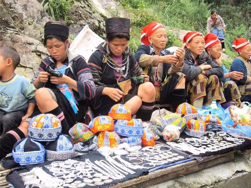 Đồng bào vùng cao bày bán đồ lưu niệm dưới chân đèo Ô Quy Hồ.