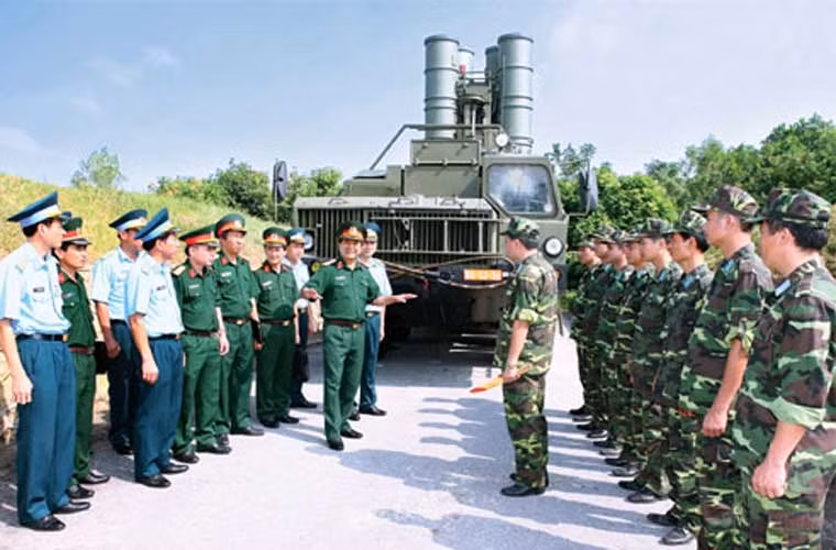 Trung tướng Võ Văn Tuấn thăm và kiểm tra công tác huấn luyện sẵn sàng chiến đấu tại Trung đoàn tên lửa 64, Sư đoàn 361. Điều đặc biệt trong bức ảnh này là việc bệ phóng tự hành tổ hợp phòng không hiện đại nhất Đông Nam Á S-300PMU-1 được lắp đủ 4 ống phóng tên lửa. Trong các lần xuất hiện trước đây, bệ phóng S-300 Việt Nam chủ yếu lắp 2 hoặc 3 đạn thay vì đầy đủ 4 đạn. Ảnh: báo QĐND