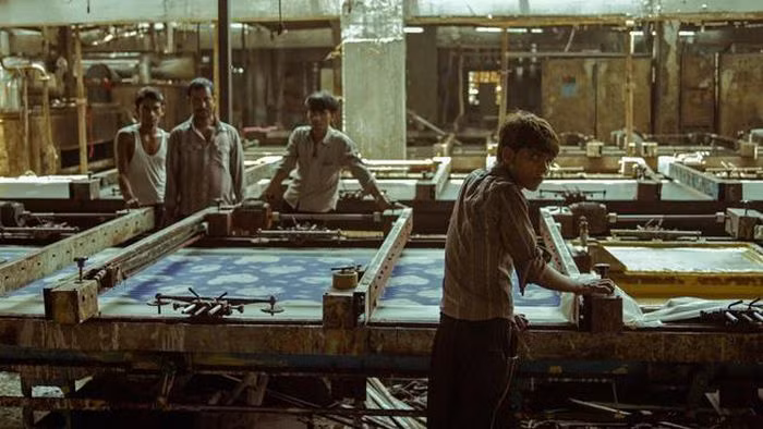 Những người công nhân ở một xưởng sản xuất quần áo giá rẻ nghỉ ngơi sau một ngày làm việc mệt mỏi.