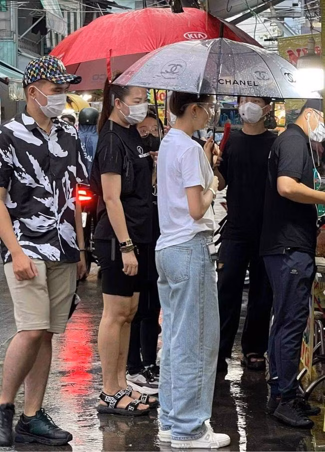 br/> Mới đây, hình ảnh Ngọc Trinh cùng ê-kíp hoành tráng xuất hiện ở một khu chợ thu hút sự chú ý của dân mạng. Qua ảnh chụp vội, Ngọc Trinh không hề đeo khẩu trang mà chỉ dùng mặt nạ chắn giọt bắn, che ô, mặc set đồ khá giản dị gồm t-shirt trắng, quần jeans thụng và sneakers.