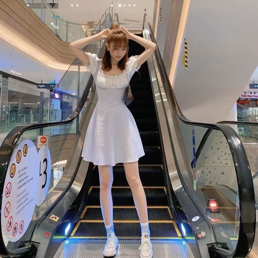 Hà Thu hack tuổi ngoạn mục với combo váy trắng cổ vuông và giày sneakers. Chiếc túi xách quai ngắn của LV chính là điểm nhấn đắt giá cho tổng thể phong cách của cô nàng này.