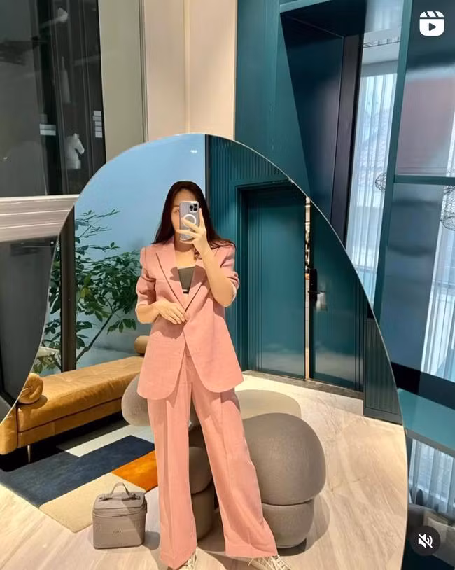 Bộ suit màu hồng pastel diện lên vô cùng ngọt ngào, tươi trẻ. Cô không mix cùng những items màu mè, sặc sỡ mà thay vào đó là mẫu áo crop top màu trung tính, cùng đôi giày sneaker nhã nhặn.