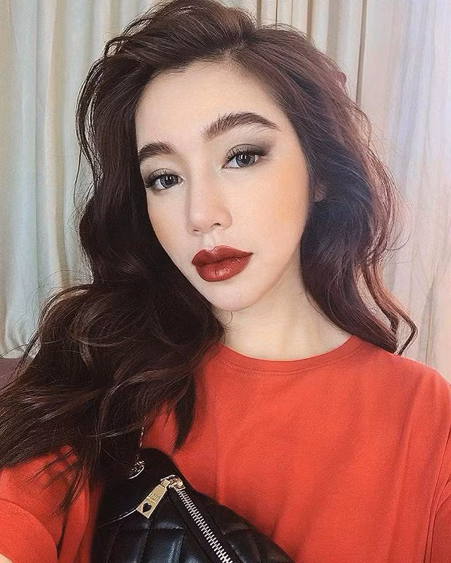 Elly Trần "đổi gió" hóa quý cô quyến rũ với tóc xoăn dài, tô son đậm và đánh mắt ấn tượng.